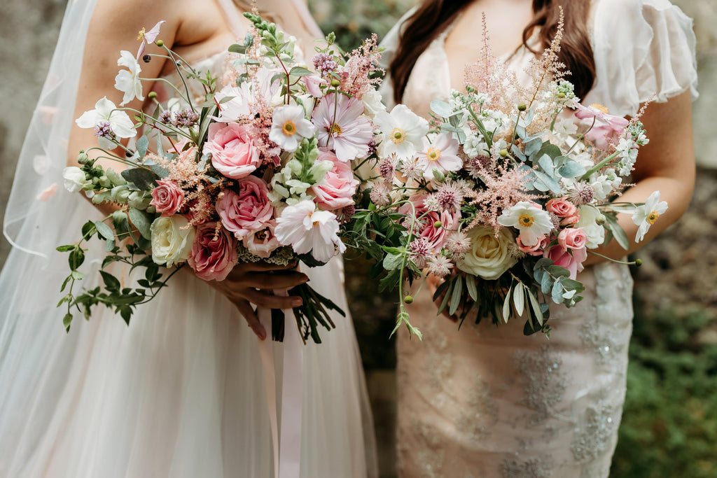 Two bridal bouquets being held by two brides